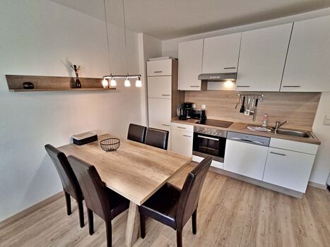 Esstisch mit voll ausgestatteter Küchenzeile