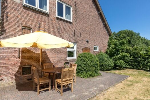 Sonnige Terrasse mit Gartengruppe und Grill