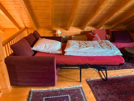 Ausgeklapptes Schlafsofa auf der offenen Wohngalerie im OG 