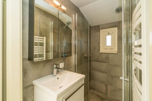 Badezimmer mit Dusche und Badmöbel 