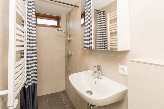 Badezimmer mit Dusche, Waschbecken und Toilette