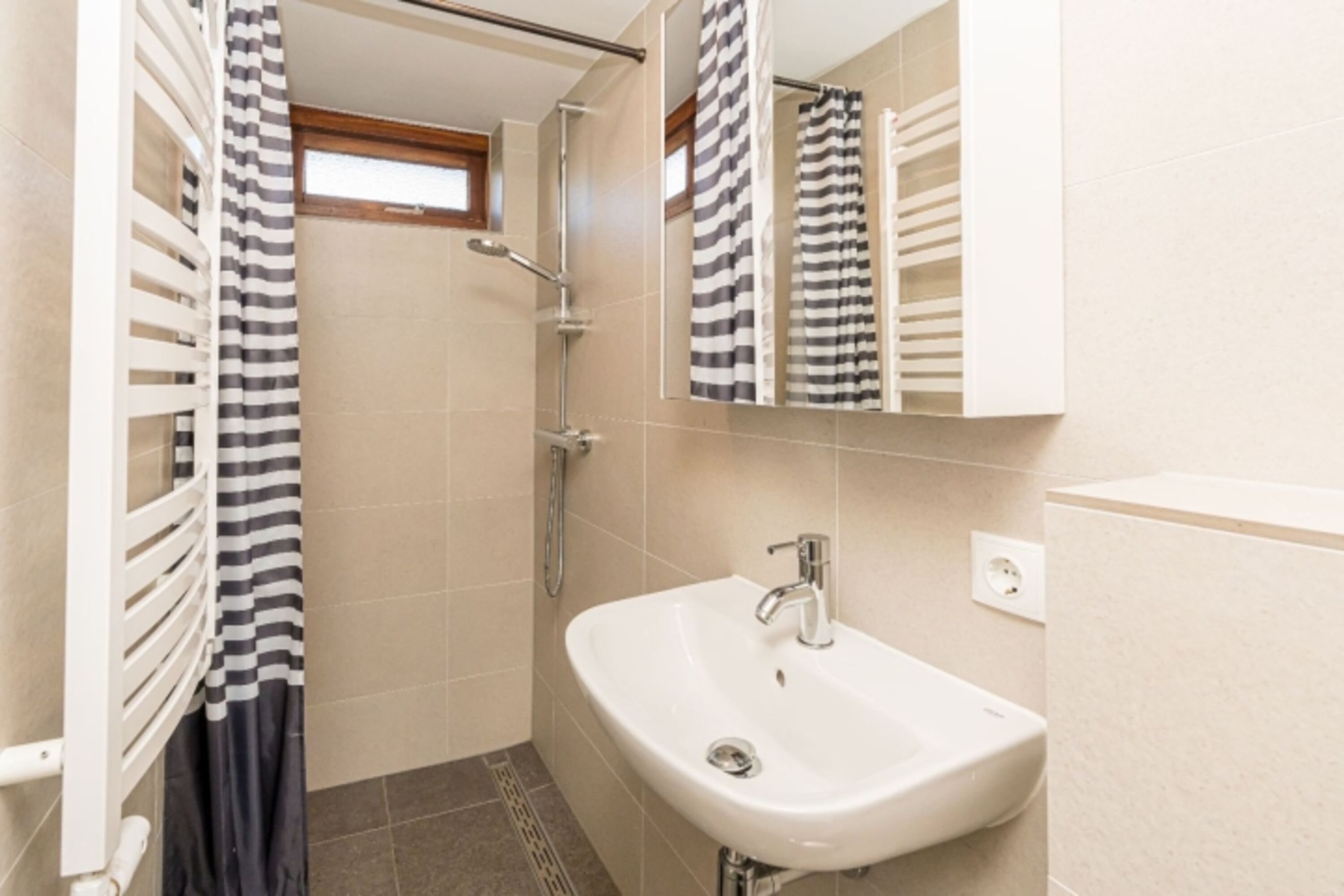 Badezimmer mit Dusche, Waschbecken und Toilette