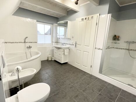 großes Badezimmer mit Dusche und Eckbadewanne