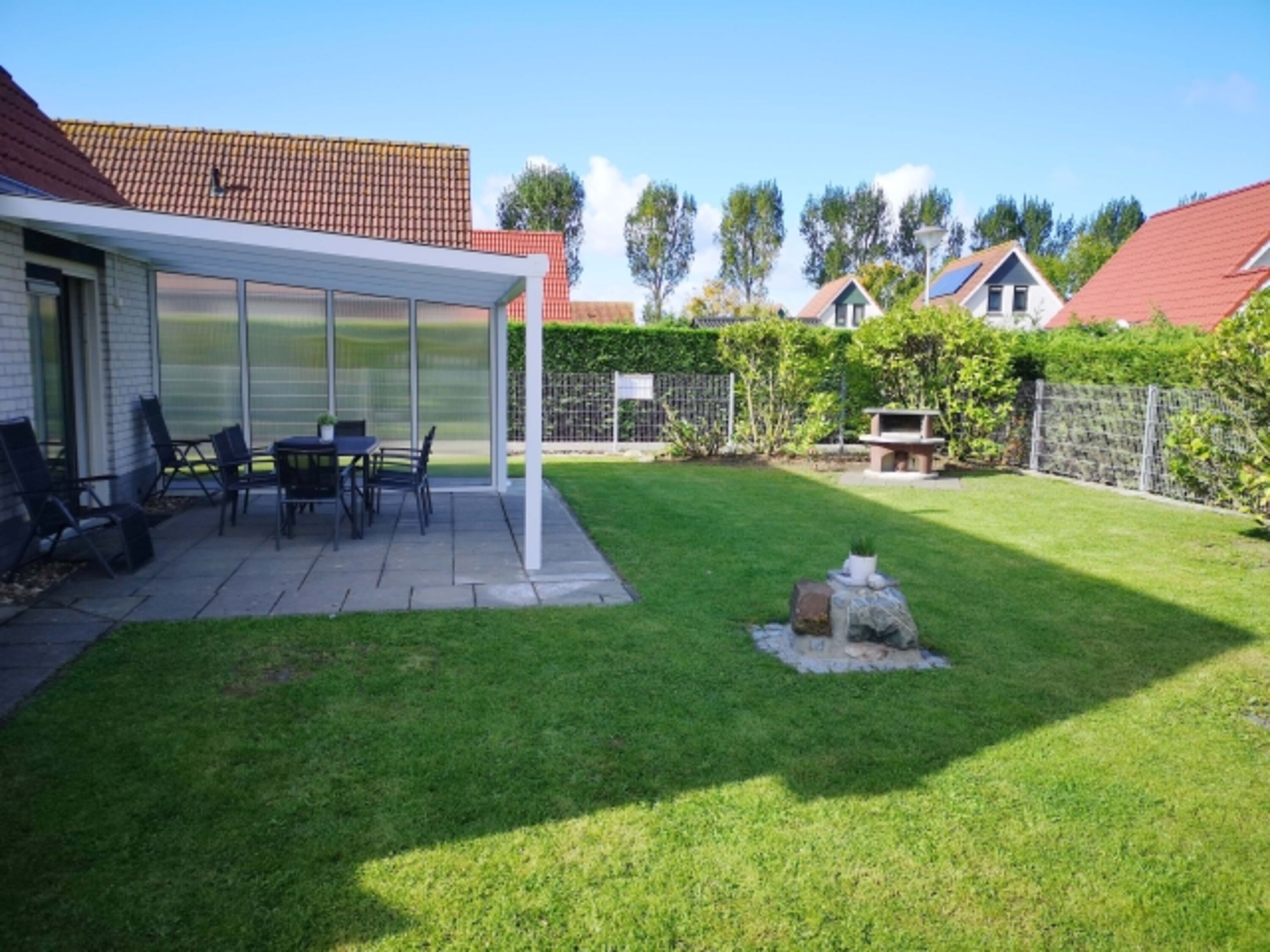 Garten mit Terrassendach und Grillkamin