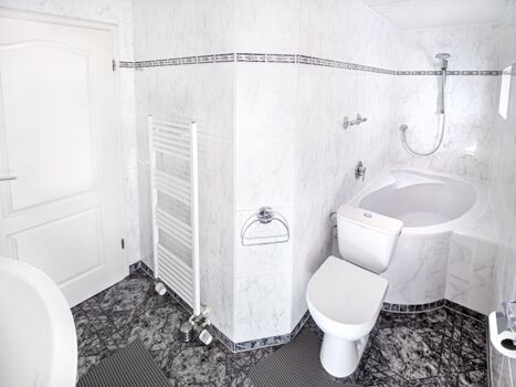 Badezimmer mit Badewanne und Dusche