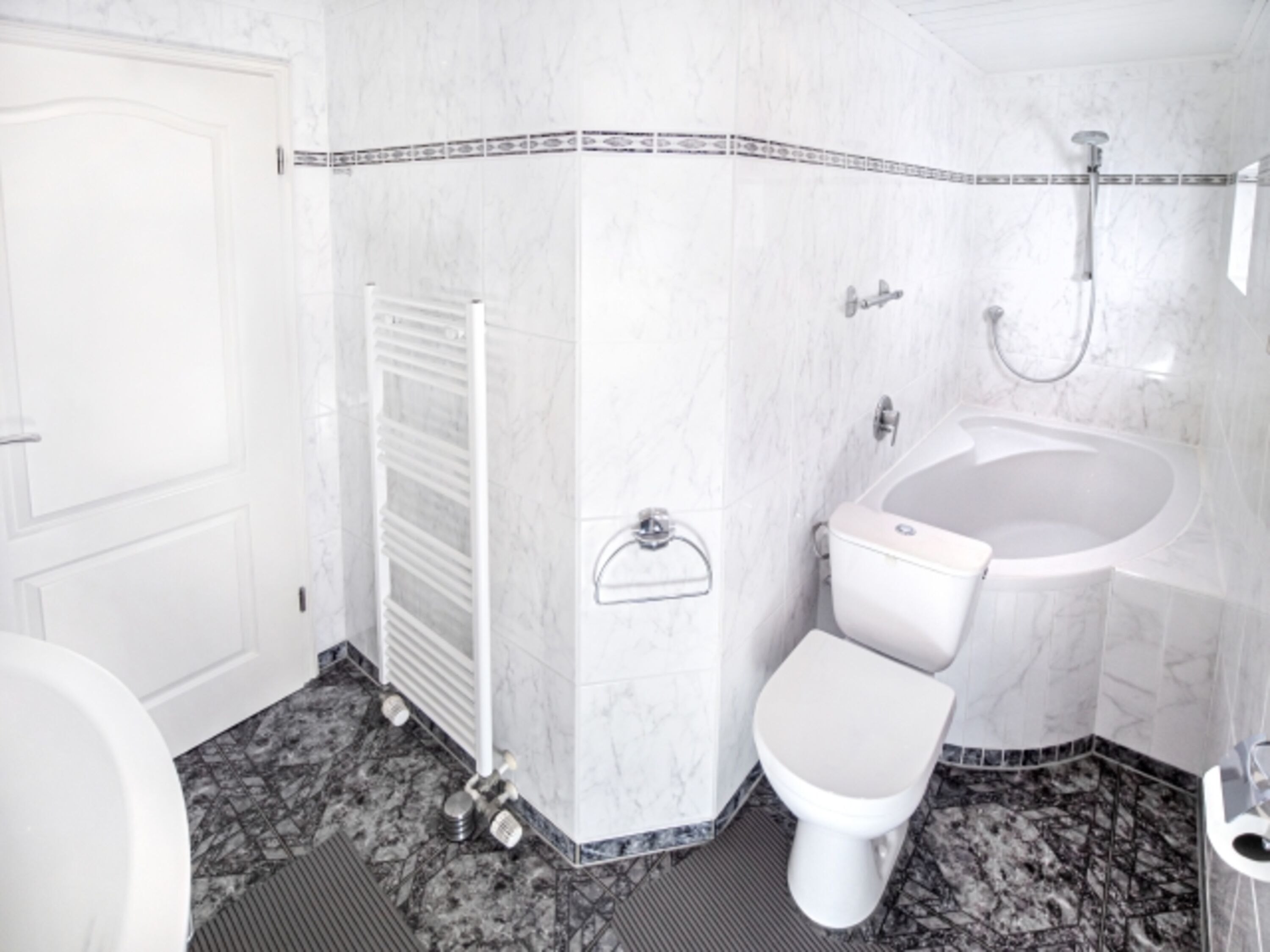 Badezimmer mit Badewanne und Dusche