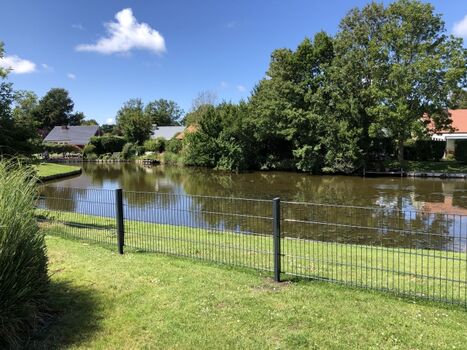 Garten mit Zaun und Teichblick