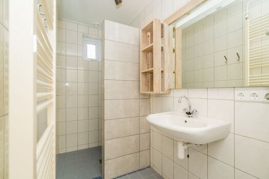 Badezimmer mit Regendusche und Waschbecken