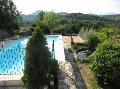 Blick über Pool und Garten bis zu den Bergen