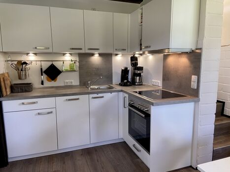 Teiloffene Küche mit separatem Spind. 