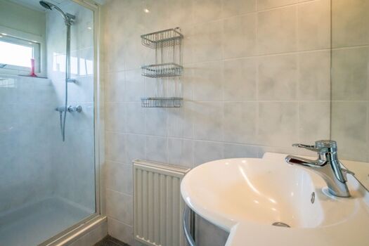 Badezimmer mit Dusche und Waschbecken