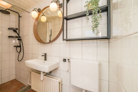 Badezimmer mit Regendusche, Toilette und Waschbecken