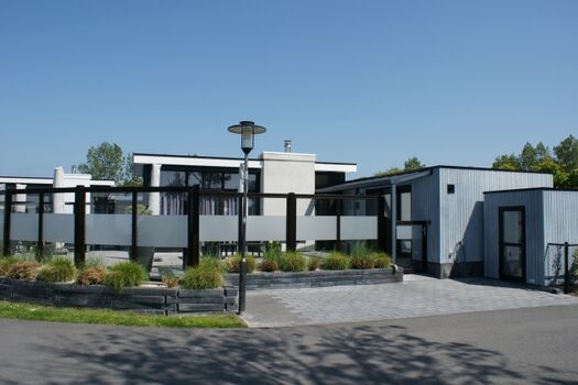 Chalet mit Terrasse, Pkw-Stellplatz, Hundedusche  und Gartenhaus und Außenansicht  