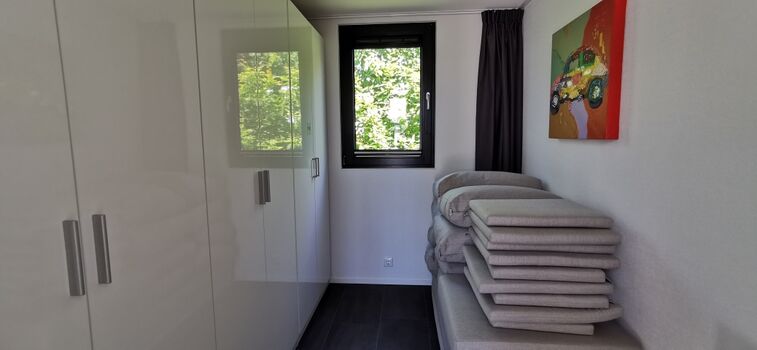 Vorrat/Ankleidezimmer mit großem Wandschrank und Sitzmöbelauflagend A