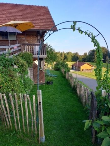 unterer Gartenbereich mit Sandkasten und Schaukel, sowie Sitzgelegenheiten und Liegestuhl
