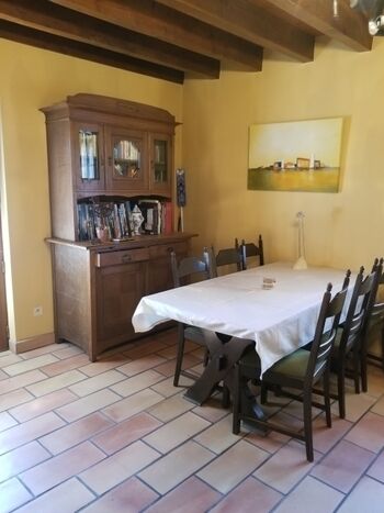 Wohnzimmer mit Bücherschrank und Tisch für 6 Personen