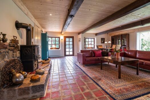 großzügiges Wohnzimmer mit Sofa und Kaminofen