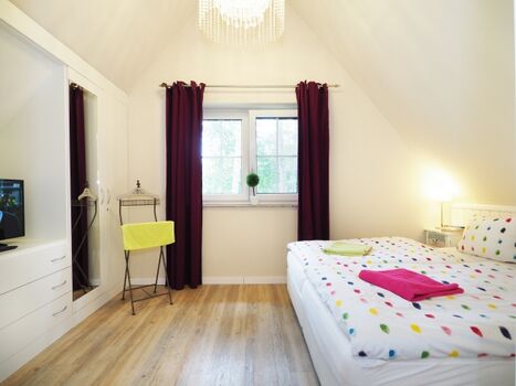 Das Schlafzimmer mit Einbauschränken und TV