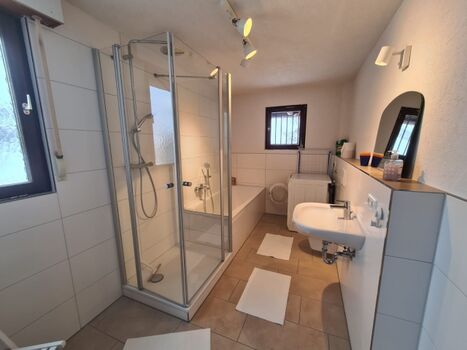 Haupt-Badezimmer mit Wanne, Dusche und Waschmaschine