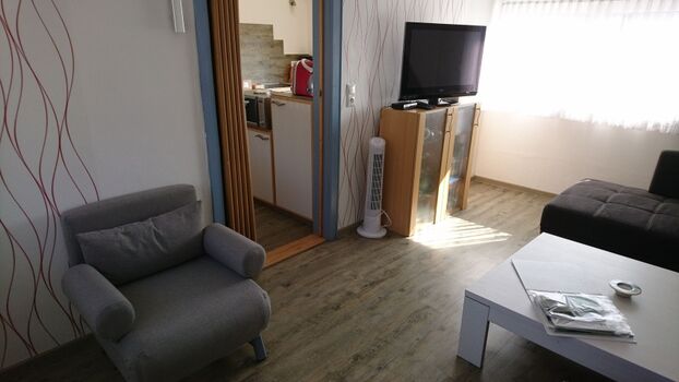 Wohnzimmer mit Fernseher, Bücherschrank mit Spielen