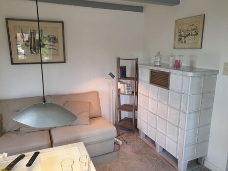 Wohnzimmer mit Kachelofen außer Betrieb, aber Heizkörperr