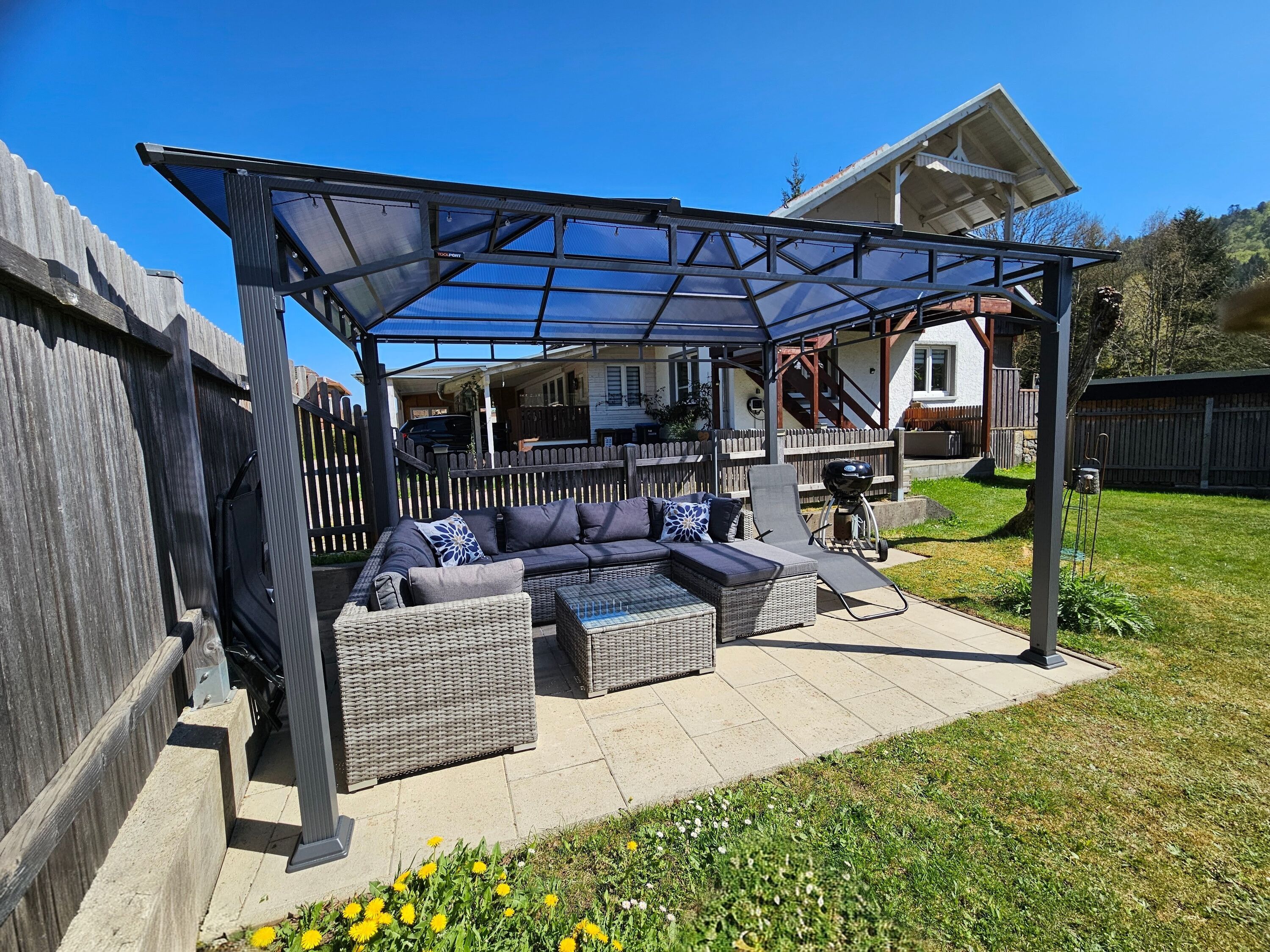 Lounge unter Pavillon mit Grill im Garten