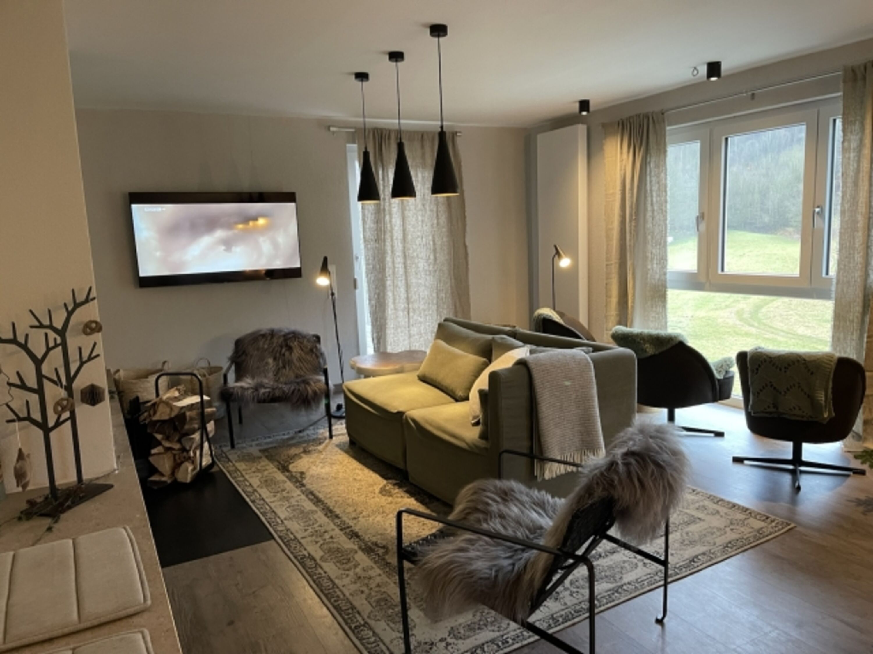 Gemütlicher Wohnbereich mit großen Fensterfronten zu Zugang zur Terrasse