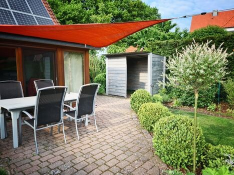 Terrasse mit Sonnensegel und Fahrradhaus