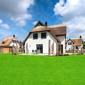 Hausansicht mit Terrassen und Gartenhaus