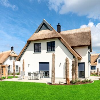 Hausansicht Gartenseite mit Terrassen und elektrischem Sonnenschutz