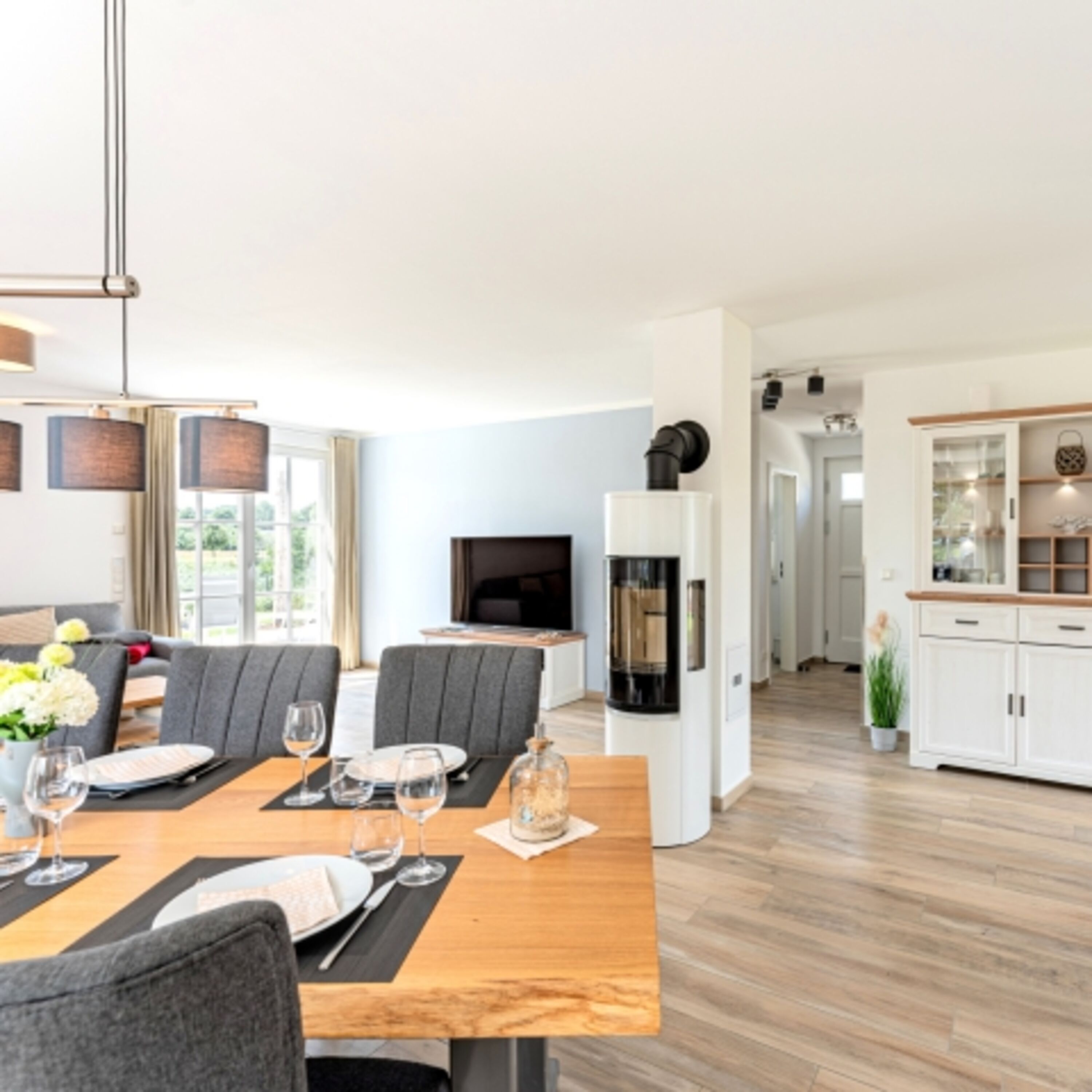 Essbereich mit Blick zum Eingangsbereich, Kaminofen und TV