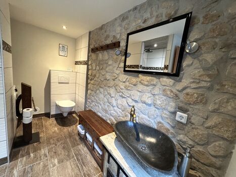 Badezimmer mit rustikaler Sandsteinwand im EG