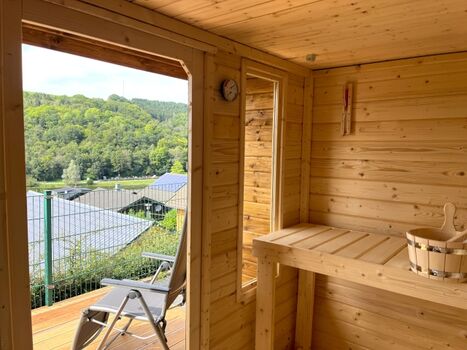 Moderne Außen-Sauna mit schönem, überdachtem Außenbereich und Liegestühlen