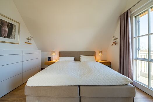 Schlafzimmer 1 mit Doppelbett, TV und Balkonzugang