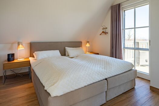 Schlafzimmer 1 mit Doppelbett, TV und Balkonzugang