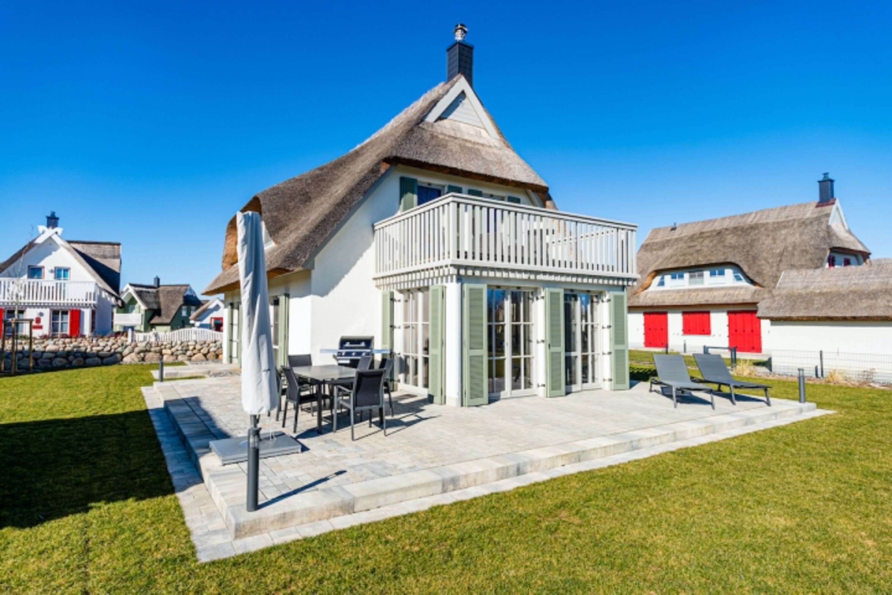 Gartenseite mit Terrassen und Balkon