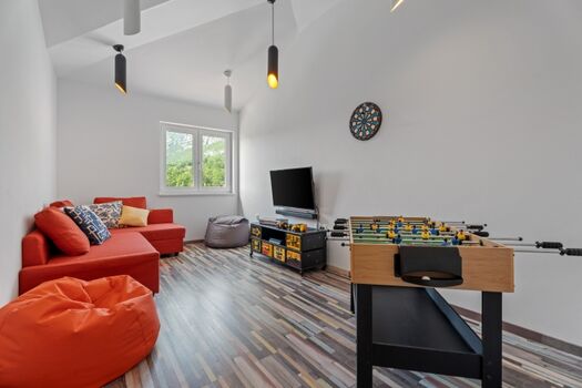 Spielzimmer mit PS4, Sofa (kann im Bett ausgeklappt werden), TV und Klimaanlage.