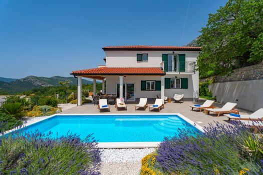 Essbereich im Freien mit Grill und Poolblick