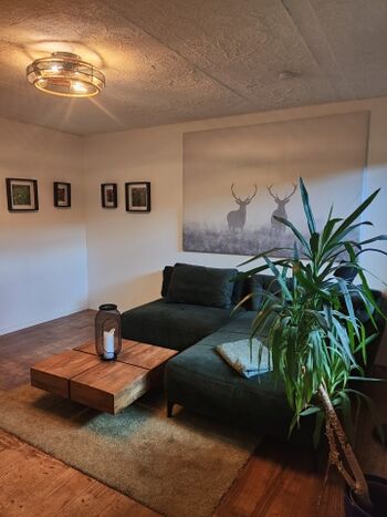 Machen Sie es sich auf der großen Couch gemütlich. Eine regulierbare Lampe unterstützt die wohlige Atmosphäre.