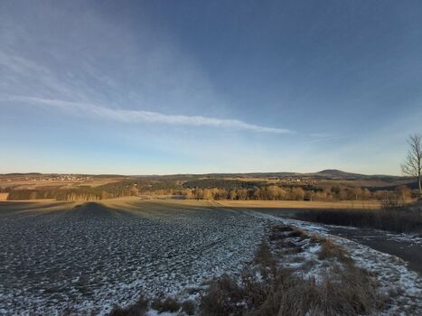 Das Foto zeigt den rheinland-pfälzischen Blick vom Ruppertsbergseifen-Forst, gelegen an der L 167, auf das nordrhein-westfälische Feriendorf Ahrdorf ,,Auf Busch''.  Im Hintergrund der ebenfalls in Rheinland-Pfalz gelegene, erhabene Aremberg mit seinen 560