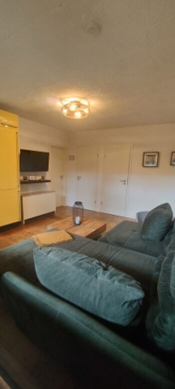 Das Wohnzimmer ist mit einem Fernseher und einem Nachtspeicherofen ausgestattet. Hier findet auch ihr vierbeinige Freund einen Platz.