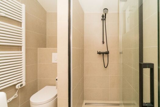 Das moderne Badezimmer mit Doppelwaschbecken, Toilette und Dusche