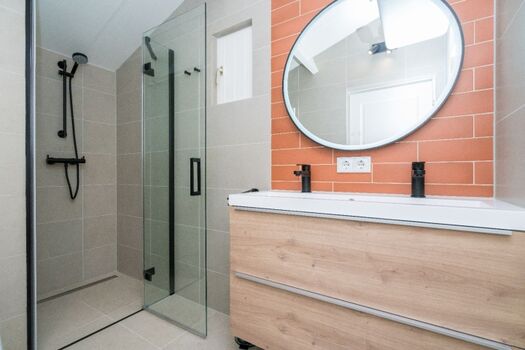 Das moderne Badezimmer mit Doppelwaschbecken, Toilette und Dusche