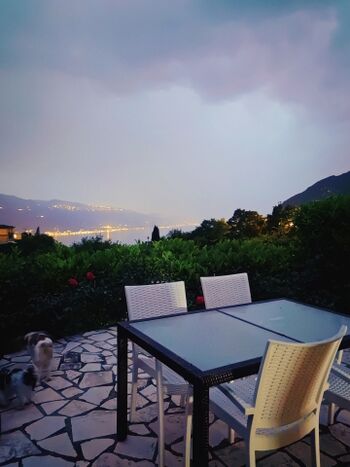 Abendstimmung auf der Terrasse nach einem Gewitter mit Blick auf den beleuchteten Gardasee.