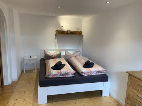 Schlafzimmer mit Doppelbett und Ausblick ins Grüne