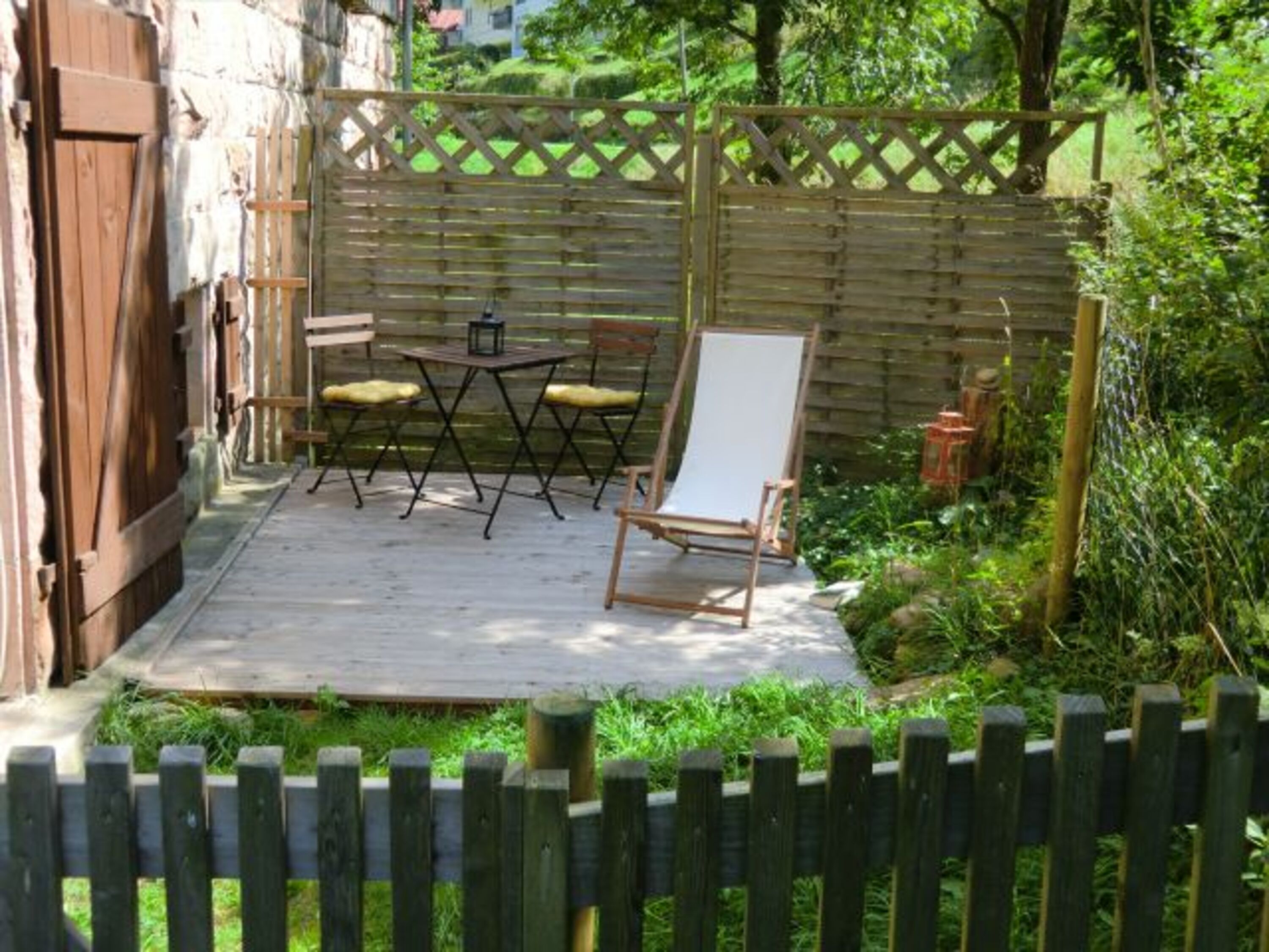Der kleine, eingezäunte Außenbereich mit Terrassendeck gehört nur Ihnen allein!