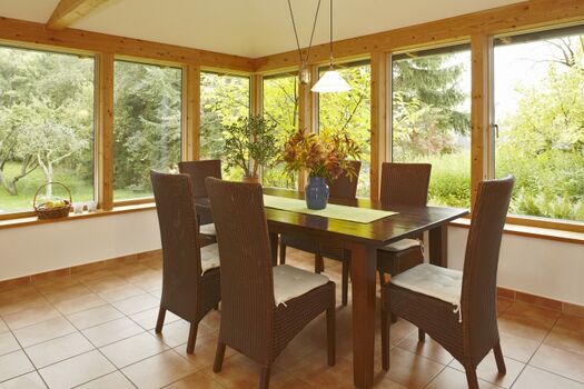 Es gibt viele schöne Plätze im Haus: hier der Wintergarten als Esszimmer...