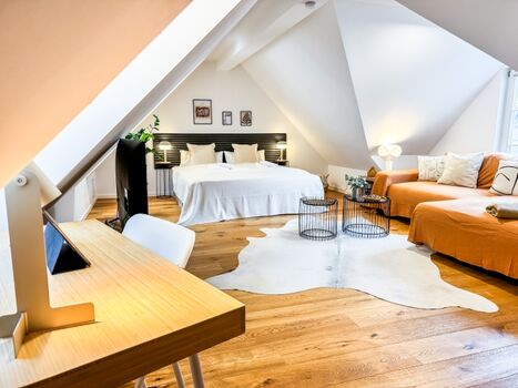 Schlafzimmer Dachgeschoss mit Schlafsofa und Schreibtisch