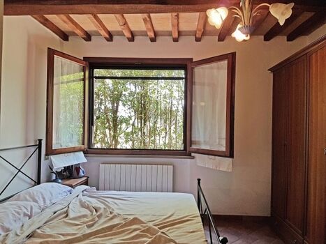 Schlafzimmer mit  Doppelbett, Fenster zum Garten