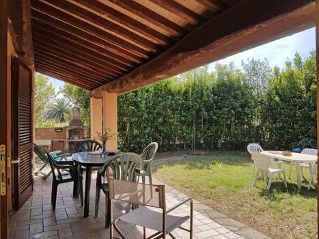 Überdachte Terrasse mit Esstisch, Blick in den Garten